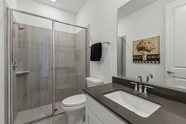 bathroom with vanity, an enclosed shower, and toilet