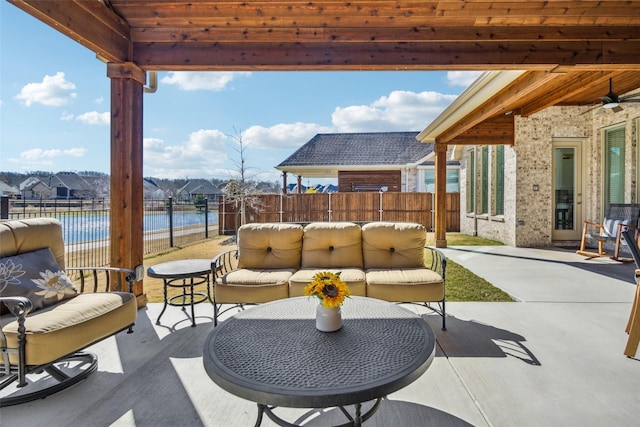 view of patio featuring a water view, outdoor lounge area, and ceiling fan