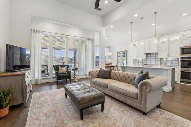 living room with dark wood-type flooring and ceiling fan