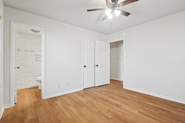 unfurnished bedroom featuring ensuite bathroom, a closet, and light wood-type flooring