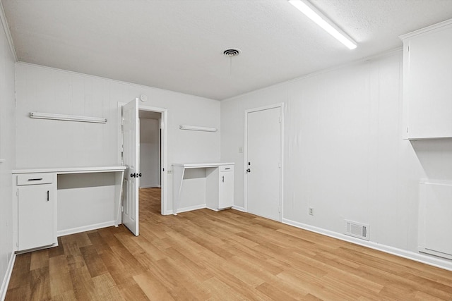 interior space with a textured ceiling and light wood-type flooring