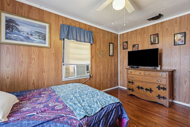 bedroom featuring ornamental molding, wooden walls, dark hardwood / wood-style floors, cooling unit, and ceiling fan