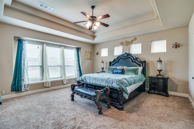 bedroom featuring carpet floors, ceiling fan, and a tray ceiling