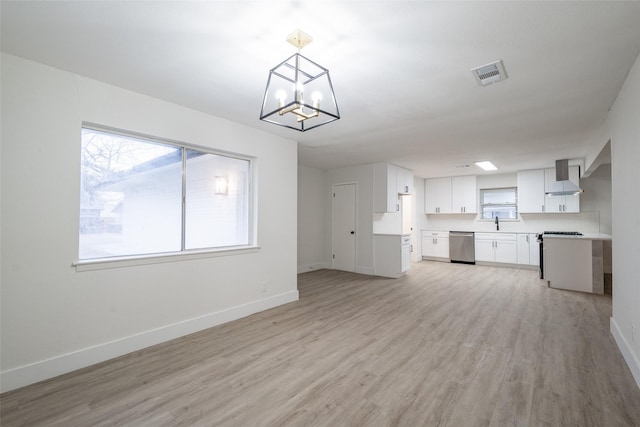 unfurnished living room featuring an inviting chandelier, sink, and light wood-type flooring