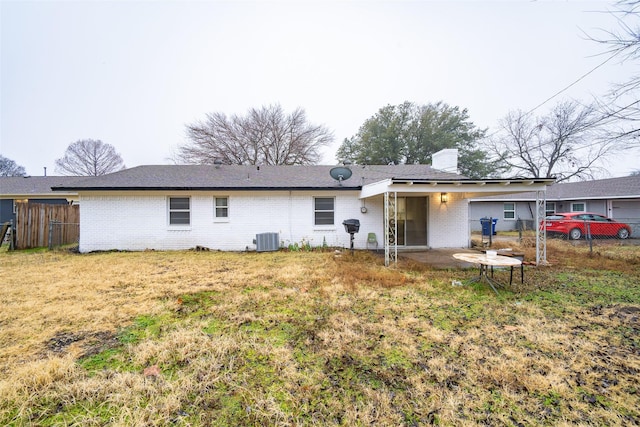 back of property with cooling unit, a patio area, and a lawn