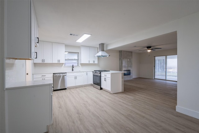 kitchen with sink, white cabinetry, a wealth of natural light, stainless steel appliances, and range hood