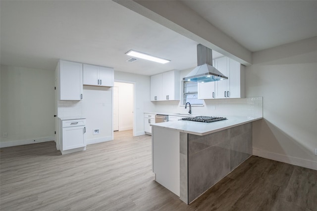 kitchen featuring sink, white cabinetry, stainless steel appliances, island range hood, and light hardwood / wood-style floors