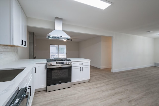 kitchen with white cabinetry, island exhaust hood, kitchen peninsula, and appliances with stainless steel finishes