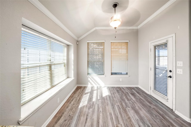 interior space with wood-type flooring, ornamental molding, and vaulted ceiling