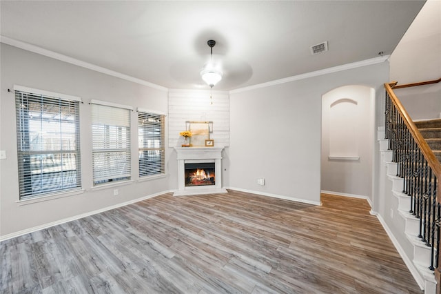 unfurnished living room featuring hardwood / wood-style flooring, ornamental molding, and ceiling fan