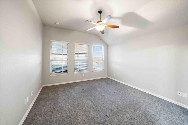 spare room featuring ceiling fan, vaulted ceiling, and dark carpet