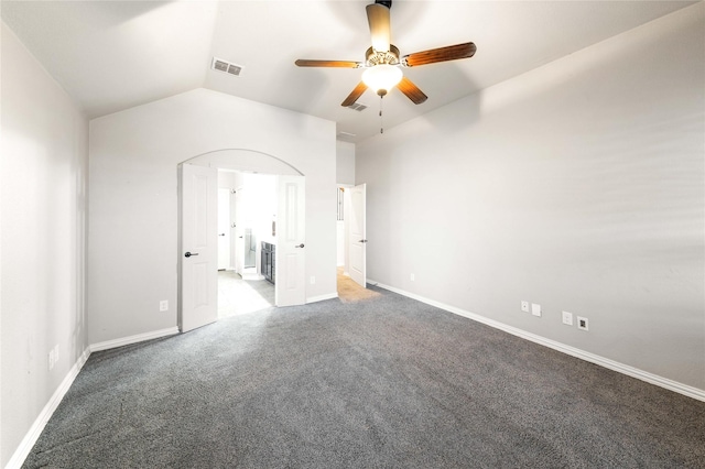 unfurnished bedroom featuring lofted ceiling, connected bathroom, ceiling fan, and carpet flooring