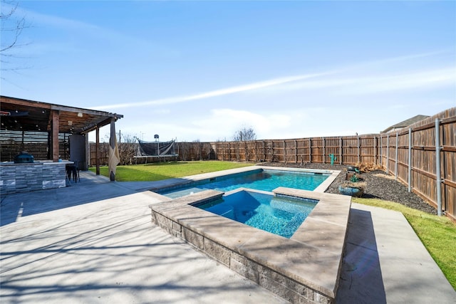 view of swimming pool featuring a patio area, exterior kitchen, a lawn, and an in ground hot tub