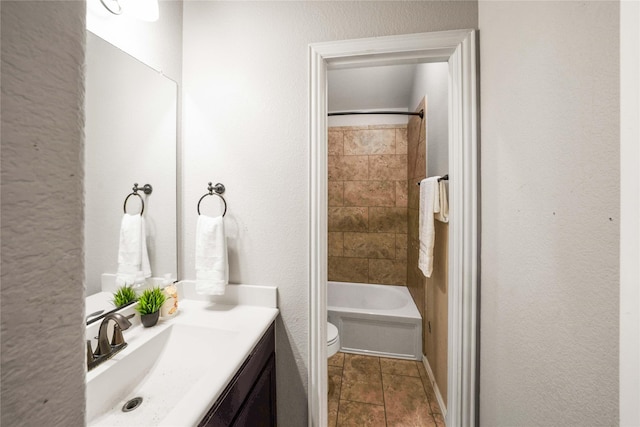 full bathroom with vanity, tiled shower / bath combo, and toilet