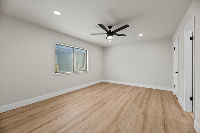 empty room with ceiling fan and light hardwood / wood-style flooring