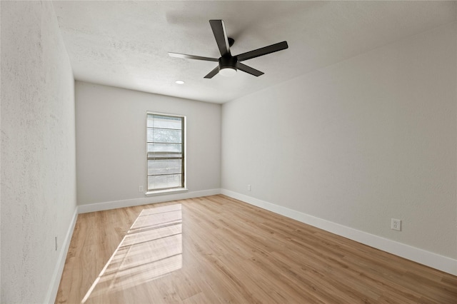 empty room featuring ceiling fan, a textured ceiling, and light wood-type flooring