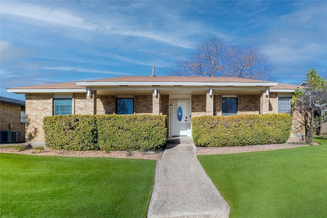 ranch-style house with a front yard and central air condition unit