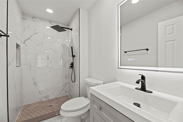 bathroom featuring vanity, toilet, and tiled shower