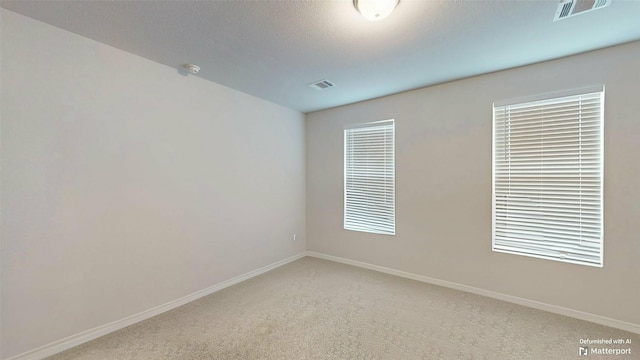 carpeted empty room featuring a textured ceiling