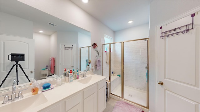 bathroom with vanity and a shower with door