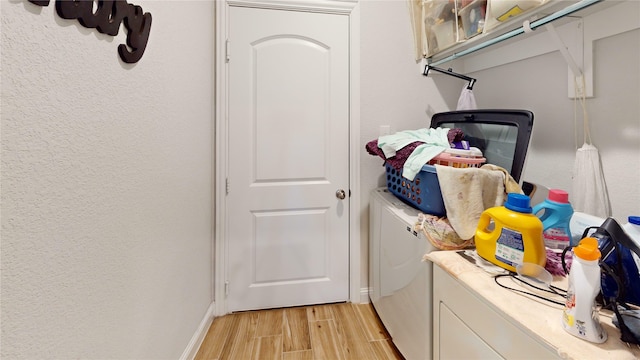 laundry area with independent washer and dryer and light hardwood / wood-style floors