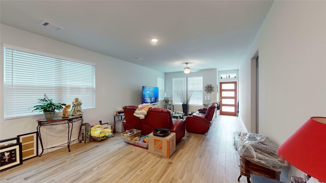 living room with light hardwood / wood-style flooring and ceiling fan