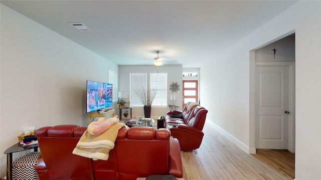 living room with ceiling fan and light hardwood / wood-style flooring