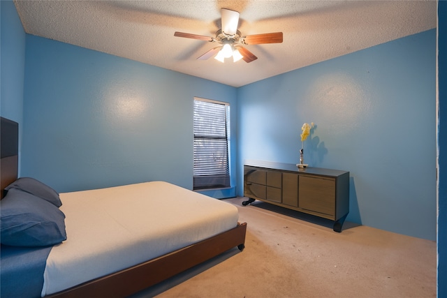 carpeted bedroom featuring ceiling fan and a textured ceiling