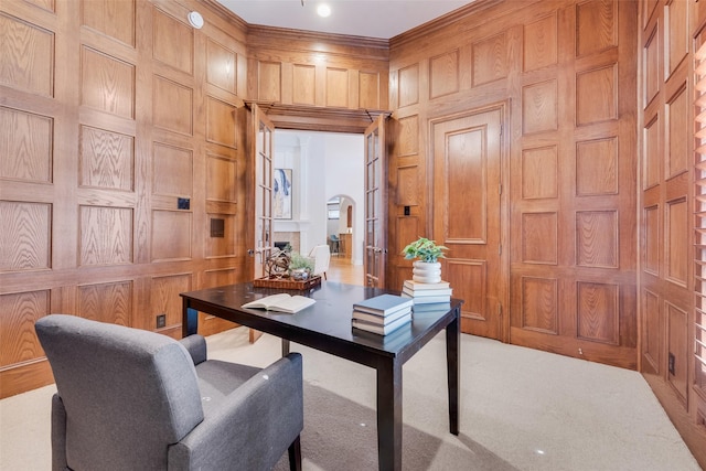 office area featuring ornamental molding, light colored carpet, and wood walls