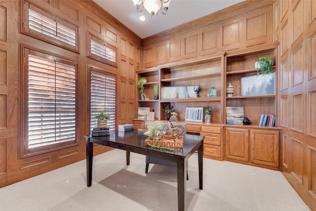 carpeted home office featuring crown molding and wood walls