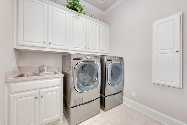 laundry room featuring cabinets, ornamental molding, sink, and washer and clothes dryer