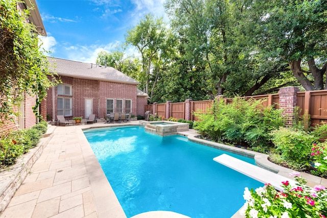 view of swimming pool featuring an in ground hot tub, a diving board, and a patio area