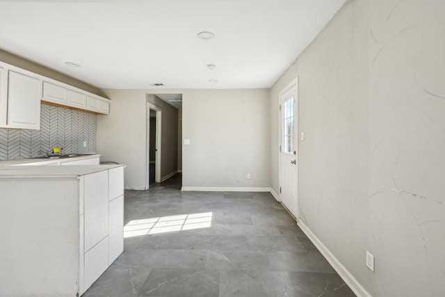 kitchen featuring white cabinets and backsplash