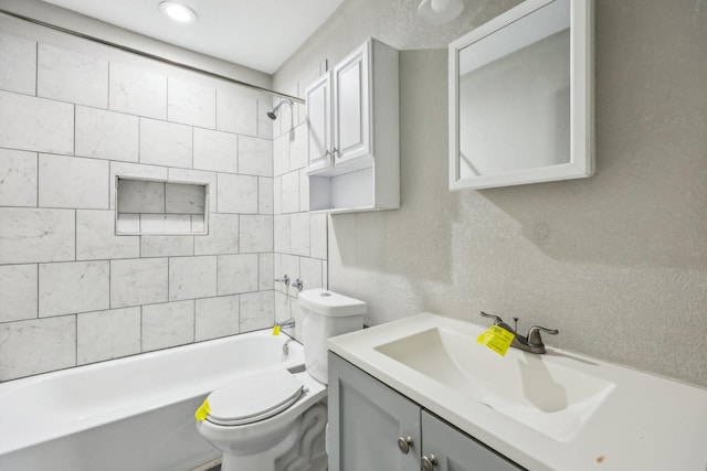 full bathroom with tiled shower / bath, vanity, and toilet