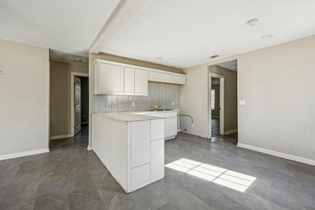 kitchen with white cabinets, sink, and backsplash