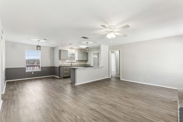 kitchen featuring dark wood-type flooring, gray cabinetry, ceiling fan, and decorative light fixtures