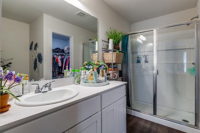 bathroom featuring hardwood / wood-style flooring, vanity, and an enclosed shower