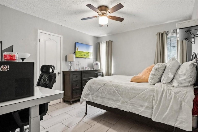 bedroom featuring multiple windows, ceiling fan, and a textured ceiling