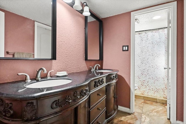 bathroom featuring vanity, toilet, and a textured ceiling