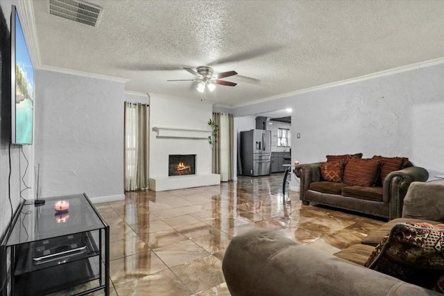 living room featuring ceiling fan, ornamental molding, and a textured ceiling