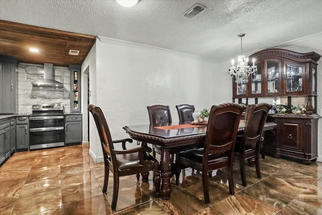 dining room featuring ornamental molding, a textured ceiling, and an inviting chandelier