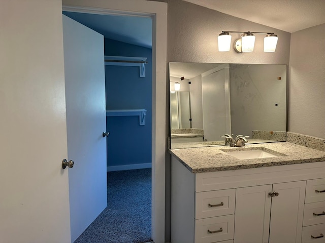 bathroom with vanity and vaulted ceiling