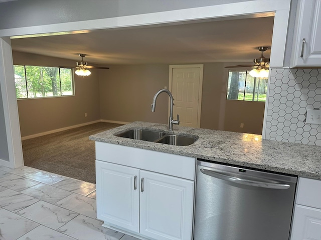 kitchen with dishwasher, light stone countertops, sink, and white cabinets