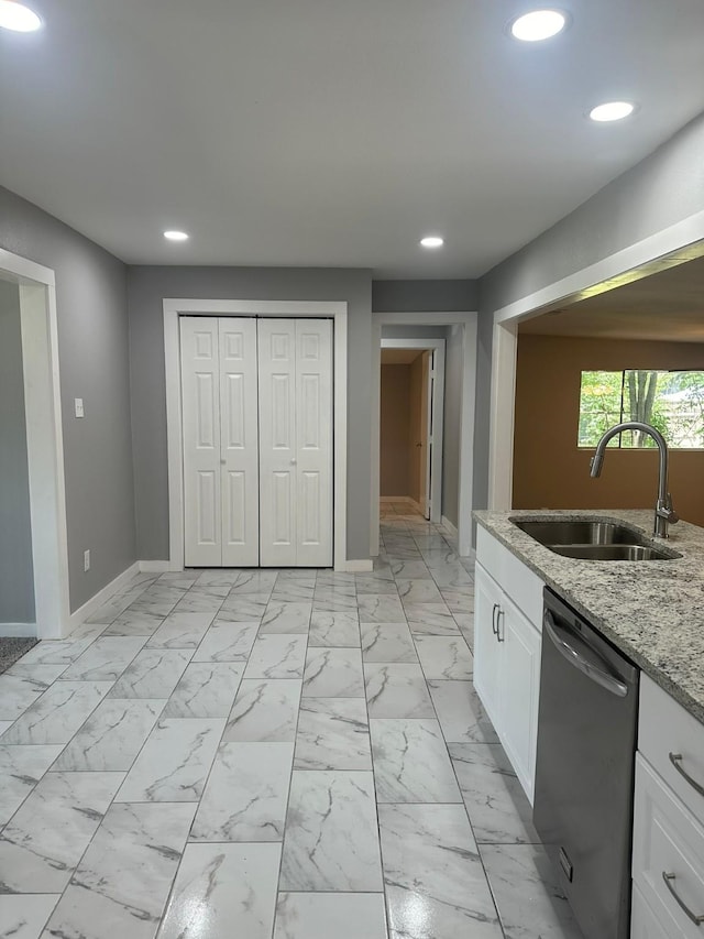 kitchen featuring white cabinets, light stone countertops, sink, and dishwasher