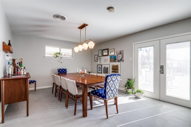 tiled dining space featuring french doors