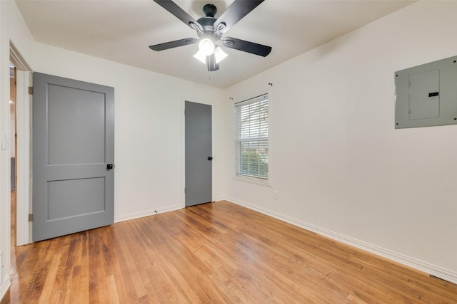 unfurnished bedroom with ceiling fan, electric panel, and light hardwood / wood-style flooring