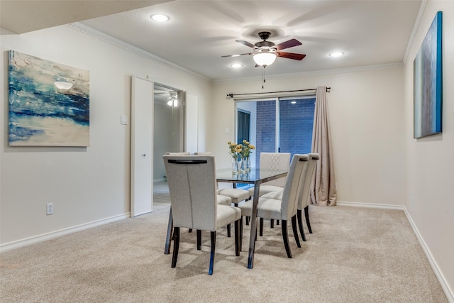 carpeted dining area with crown molding and ceiling fan