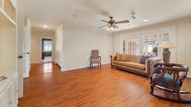 living room featuring french doors, ceiling fan, crown molding, and light hardwood / wood-style flooring