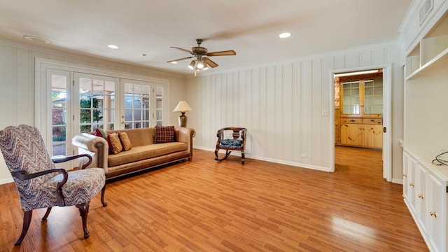 living area with ornamental molding, light wood-type flooring, and french doors