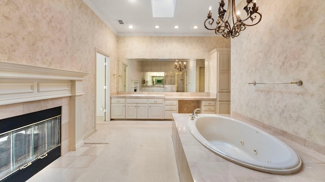 bathroom featuring crown molding, a tile fireplace, a relaxing tiled tub, vanity, and a chandelier